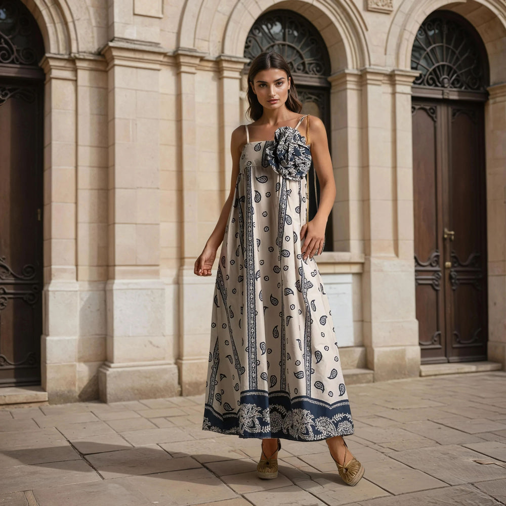 Model wearing paisley cotton maxi dress with large floral detail and espadrilles in elegant city backdrop