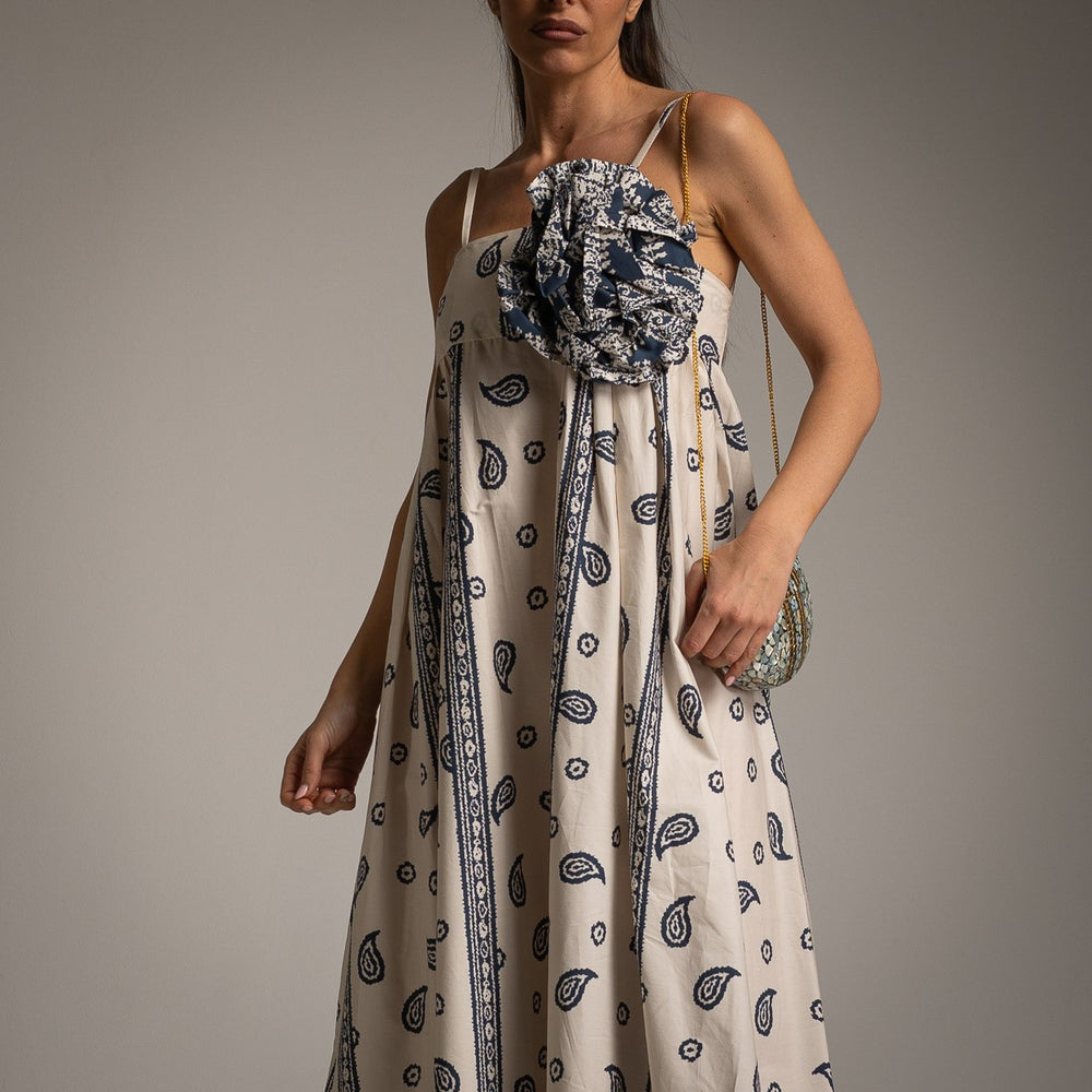 Close-up of boho maxi dress with oversized removable flower and blue paisley print