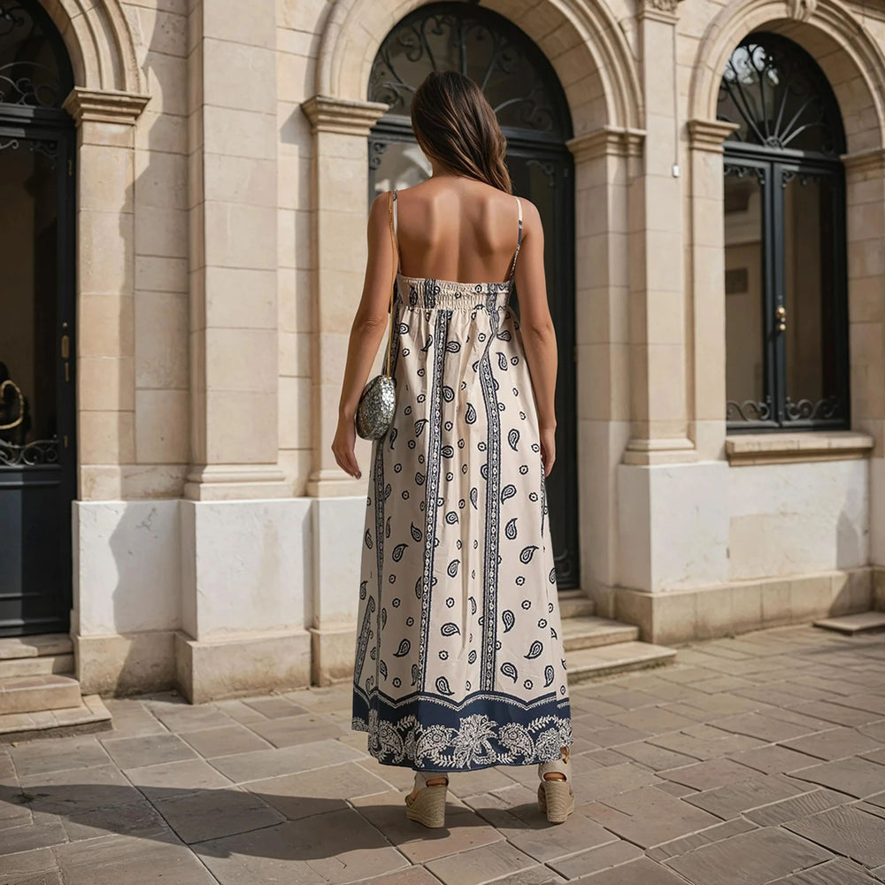 Back view of paisley maxi dress with smocked panel and adjustable straps in cream and navy print