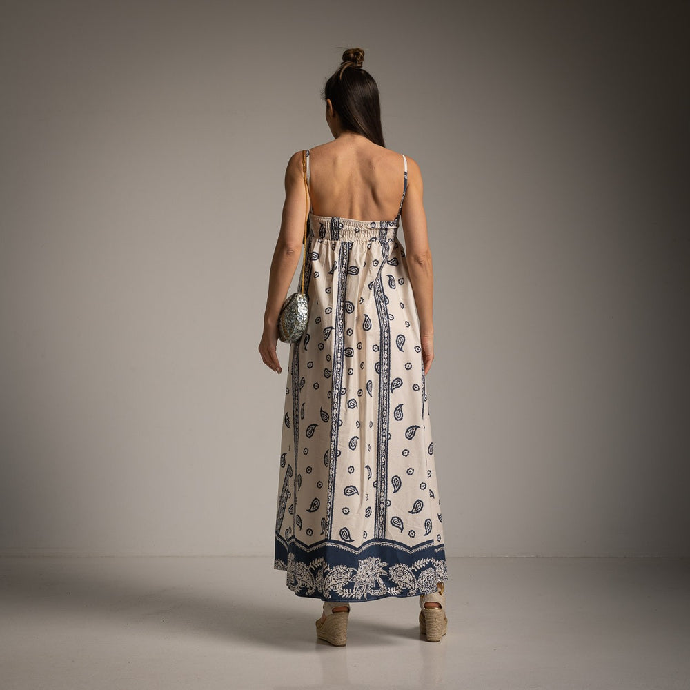 Studio back view of cream maxi dress with navy paisley pattern and flowy hem