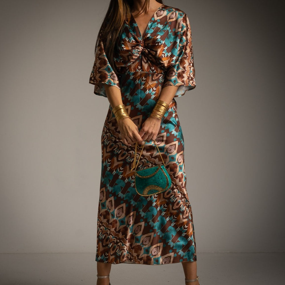 Close-up of satin kimono dress in Toscana style with teal and brown print and twisted neckline