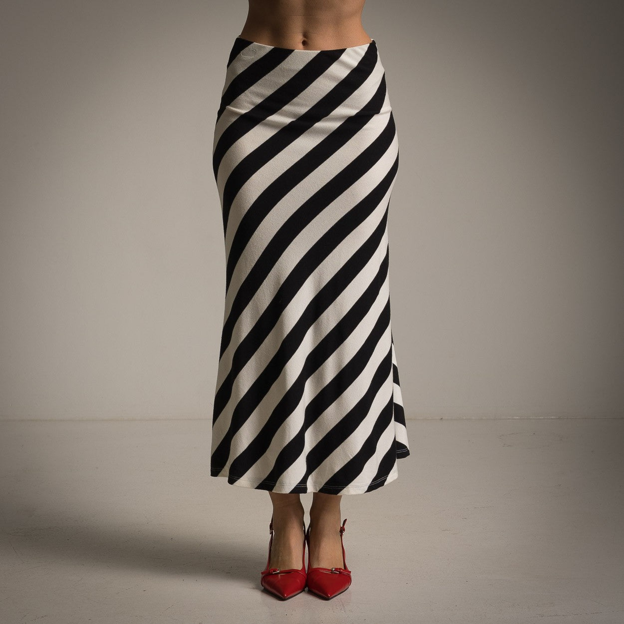 Front view of striped black midi skirt paired with red heels