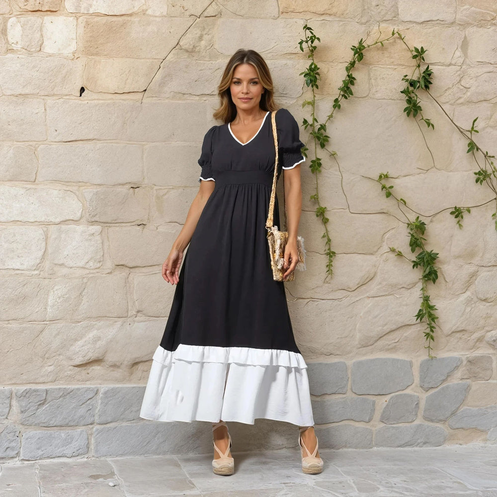 Front view of black and off-white midi dress with white contrast neckline and ruffle hem