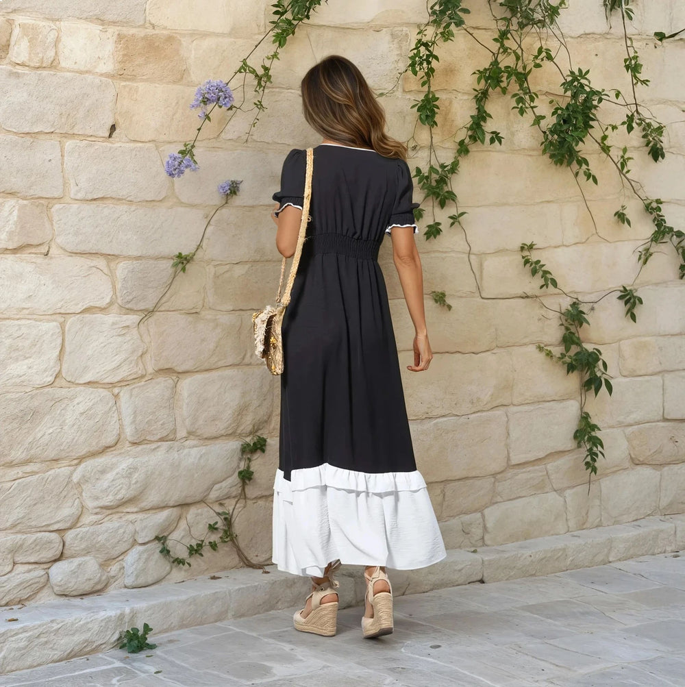 Back view of two-tone black and off-white midi dress with shirred waist and puff sleeves