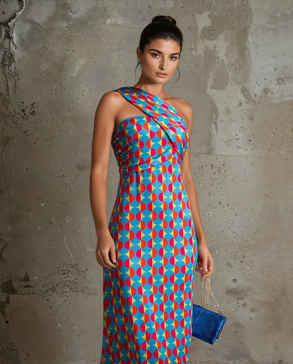 Close-up of colorful one-shoulder midi dress featuring bold circular patterns in red, turquoise, and blue tones