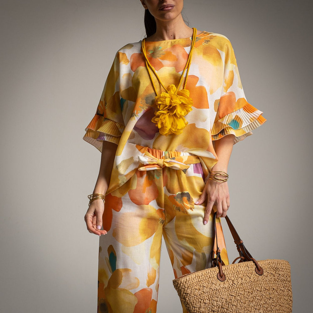 Detailed view of yellow floral two-piece outfit with pleated sleeve design
