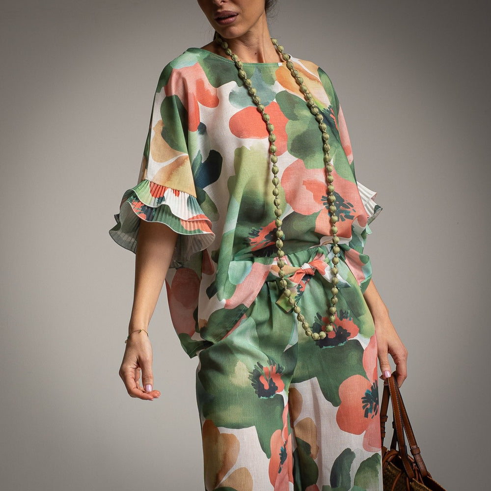 Close-up of green floral print co-ord with bow detail and statement necklace