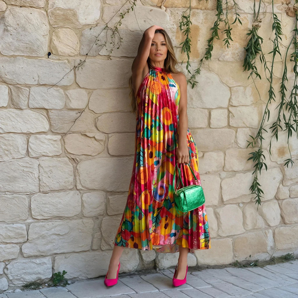 Fuchsia color variant of the pleated dress with colorful geometric print, paired with a green handbag and pink heels.