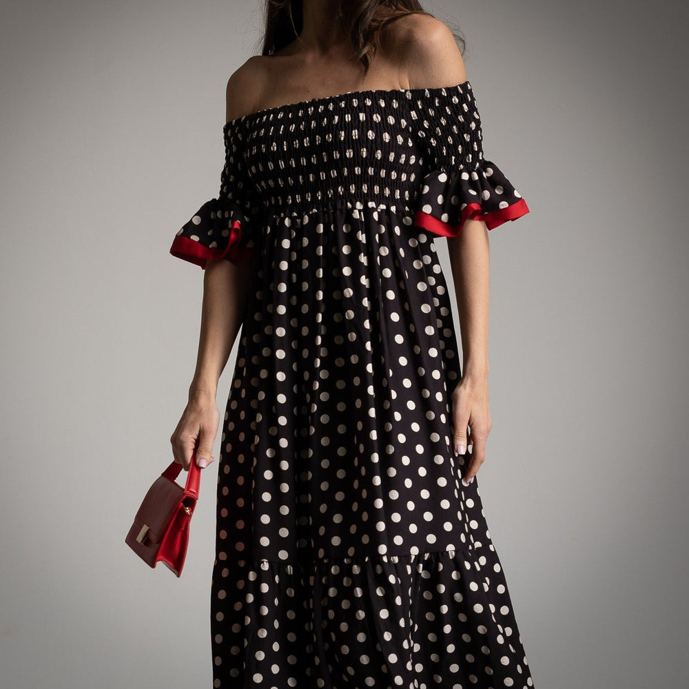 Close up of a model wearing off-shoulder polka dot maxi dress with red ruffle sleeves