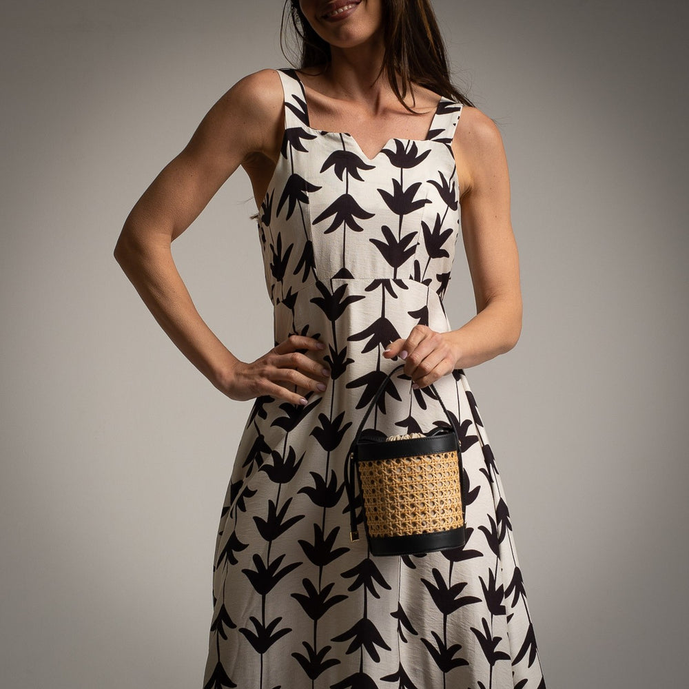 Close-up of white dress with black leaf design and elegant cut-out neckline