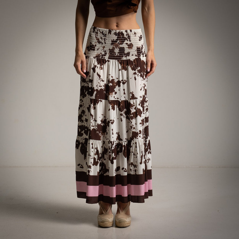 Front view of abstract print maxi skirt in brown and cream with pink accent border.