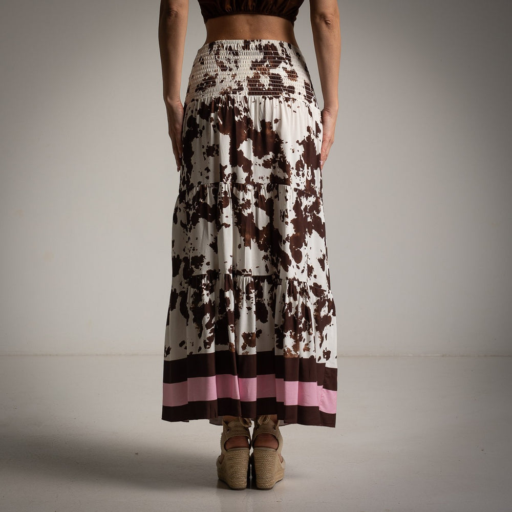 Back view of flowy brown and white patterned skirt with wide pink hemline.