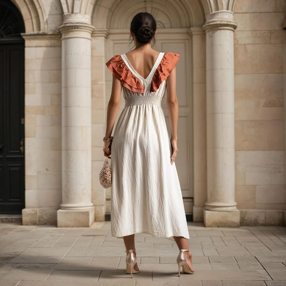 Back view of a cream-colored ruffled midi dress with a flowy silhouette, worn by a model in an urban outdoor setting.