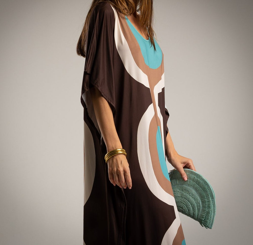 Close-up of the retro dress showing colorful pattern details and golden bangles.