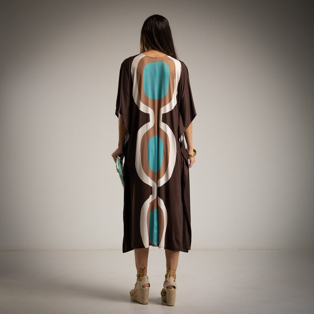 Back view of the oversized midi dress featuring bold, abstract turquoise and beige design on brown fabric.