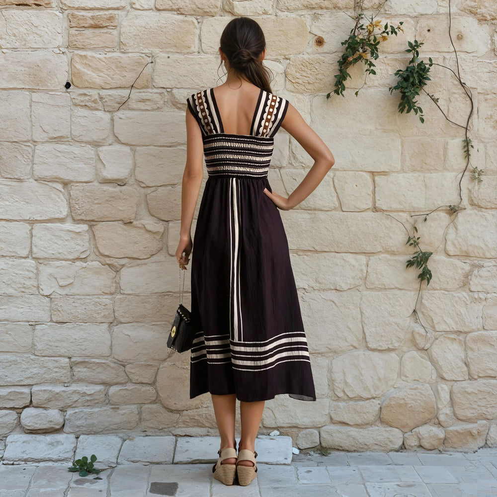 Back view of black cut-out midi dress with smocked elastic band and striped details