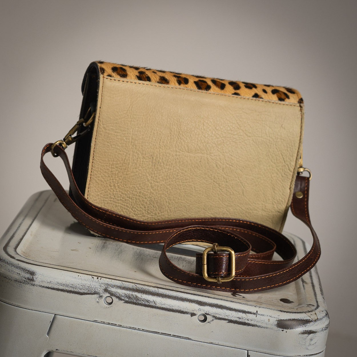 Light leather back view of cheetah crossbody bag with adjustable strap