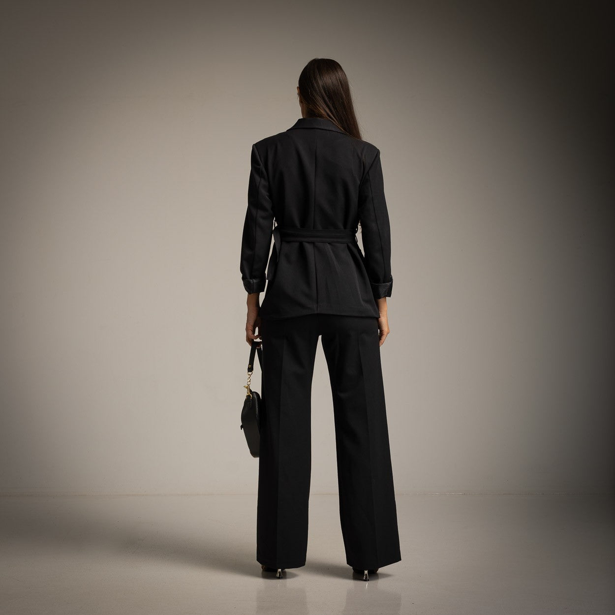 Back view of black tailored blazer with waist belt by MARIΓIOÚ