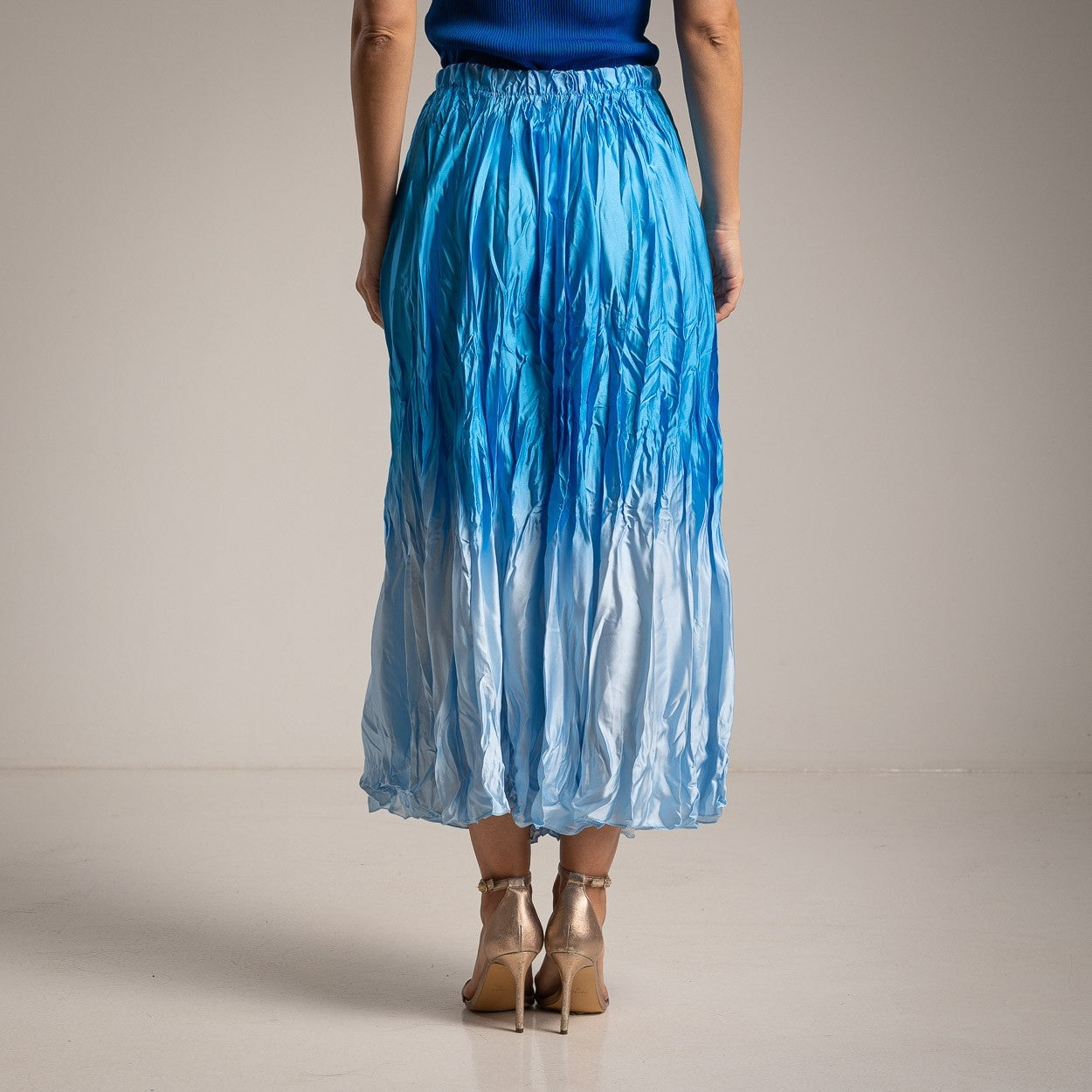 Back view of MARIΓIOÚ blue gradient satin crinkle midi skirt with elastic waistband