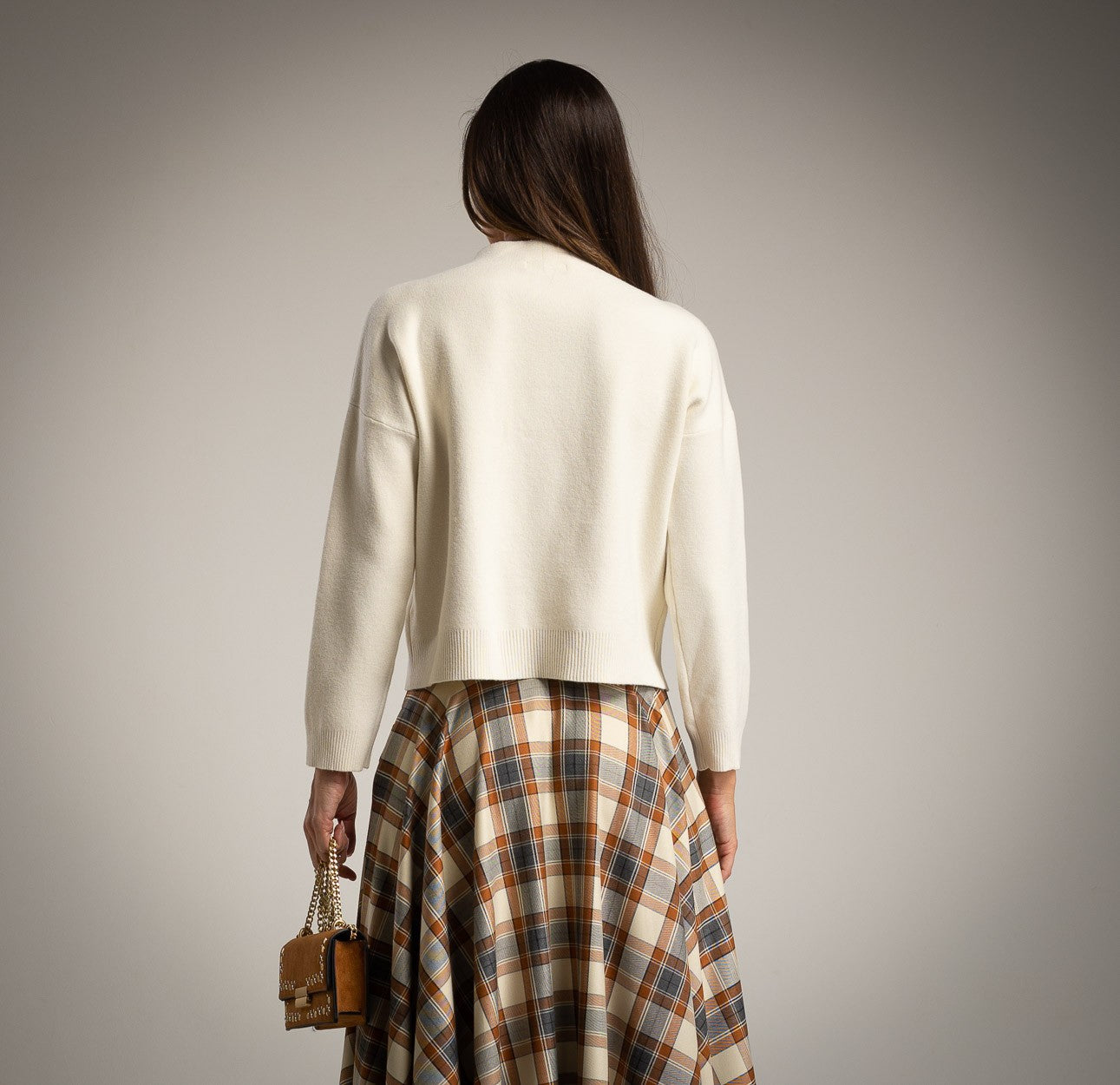 Back view of creme teddy bear sweater paired with checked skirt by MARIΓIOÚ