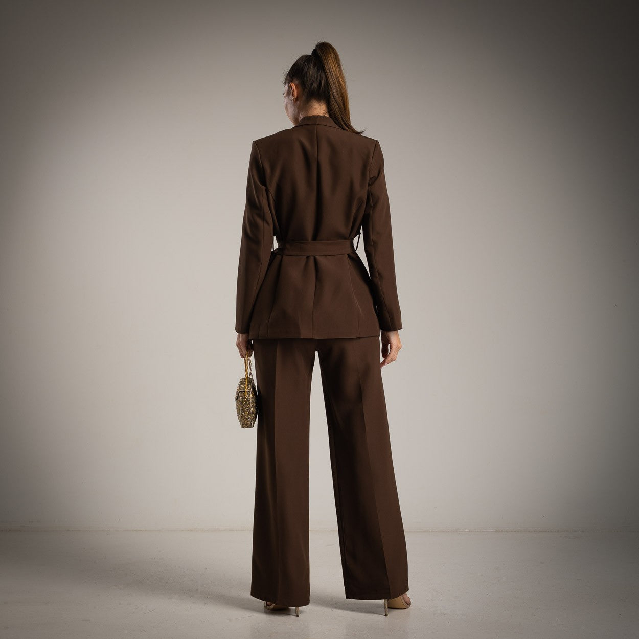Model wearing MARIΓIOÚ brown blazer and wide-leg pants set – back view, fall/winter collection, made in Italy.