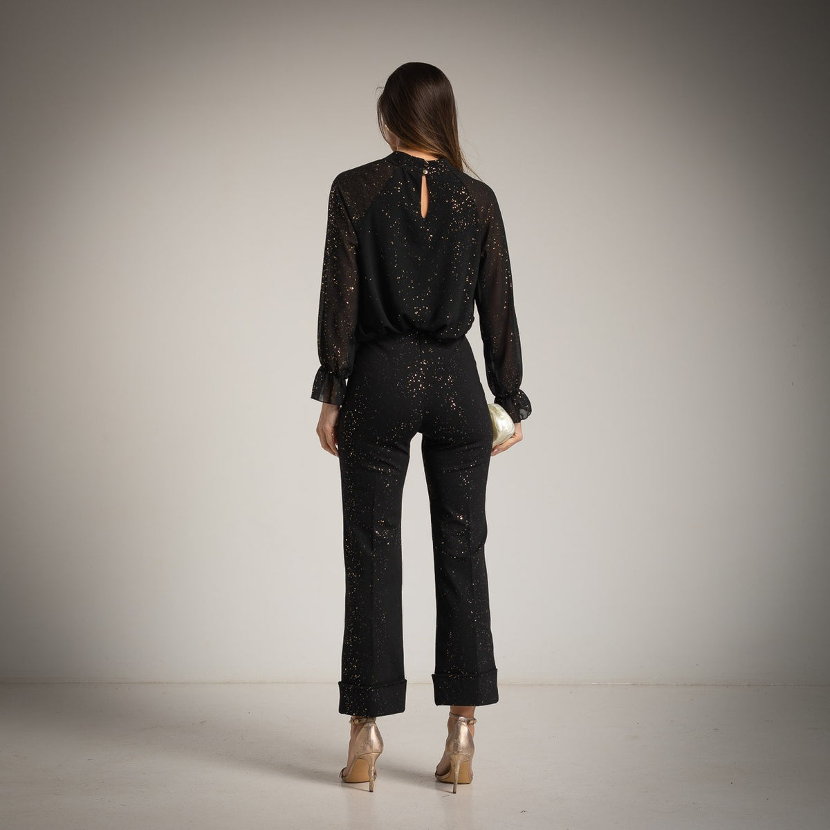 Black sheer chiffon blouse with high gathered neckline, ruffled cuffs and golden glitter foil - back view