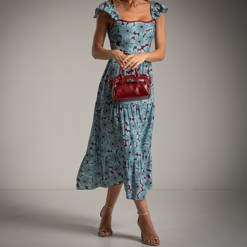 Front detail of MARIΓIOÚ blue floral viscose midi dress with flutter sleeves – styled with red handbag