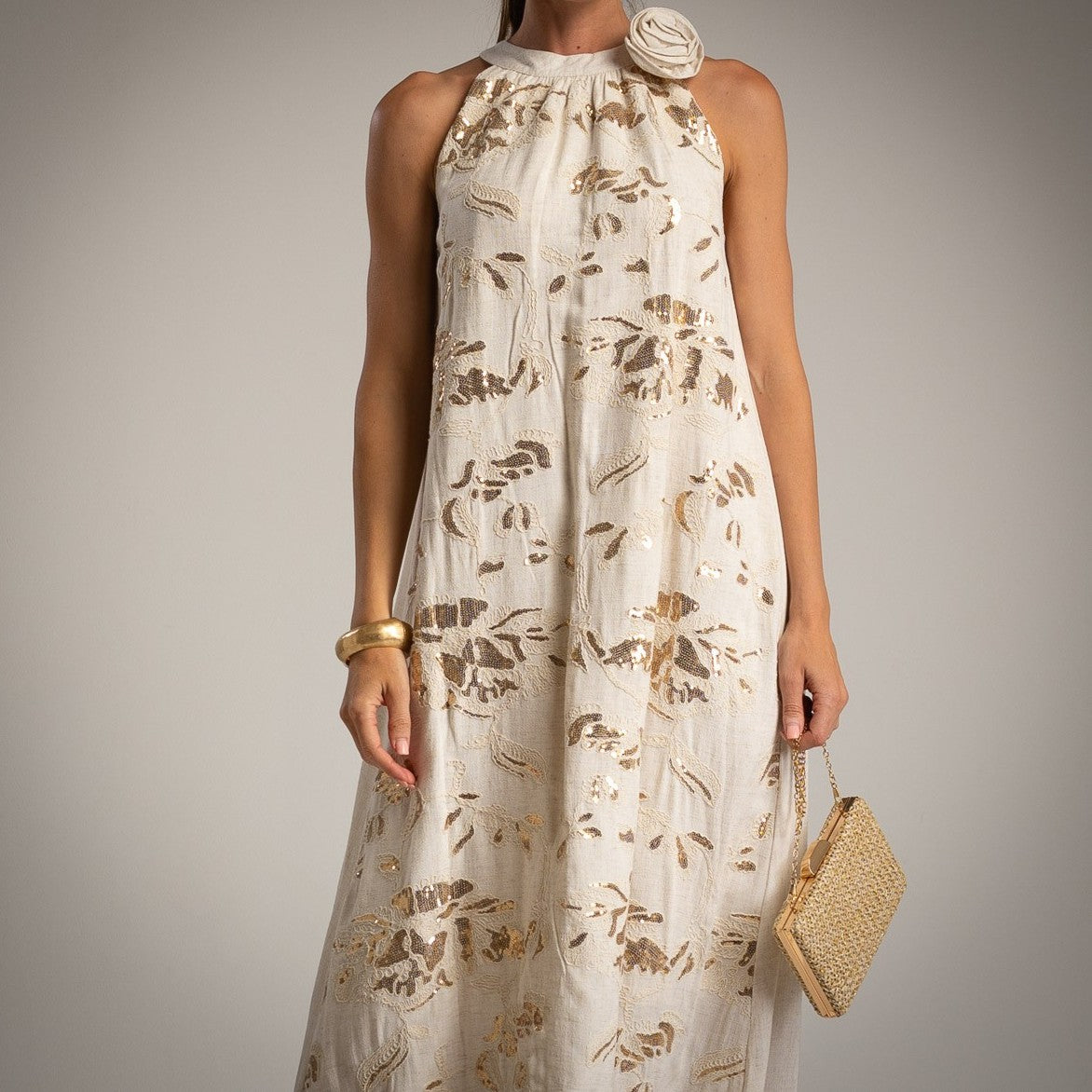 Close-up of halterneck dress with golden floral embroidery and flower detail – MARIΓIOÚ