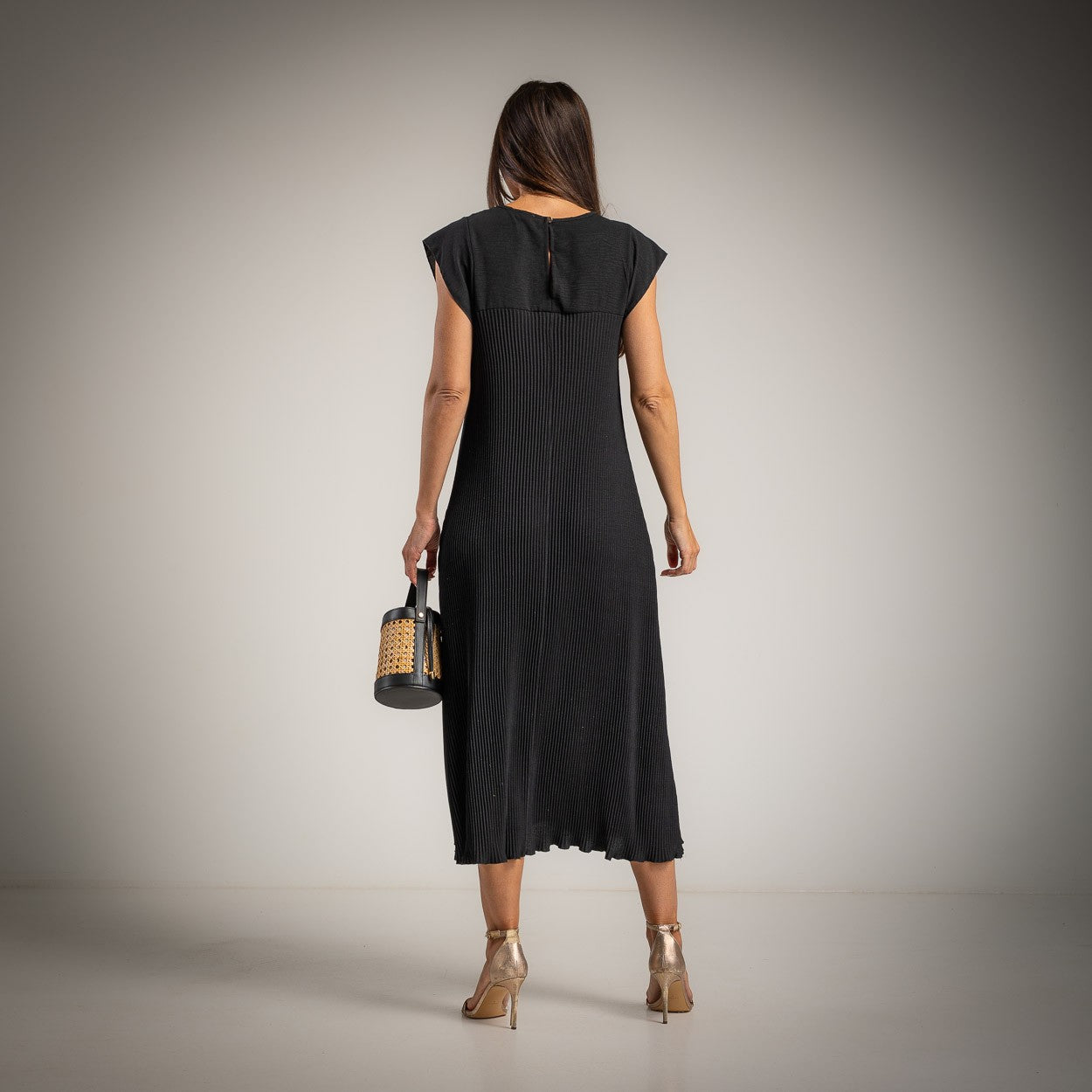 Back view of black micro pleated midi dress with elegant flowing fit