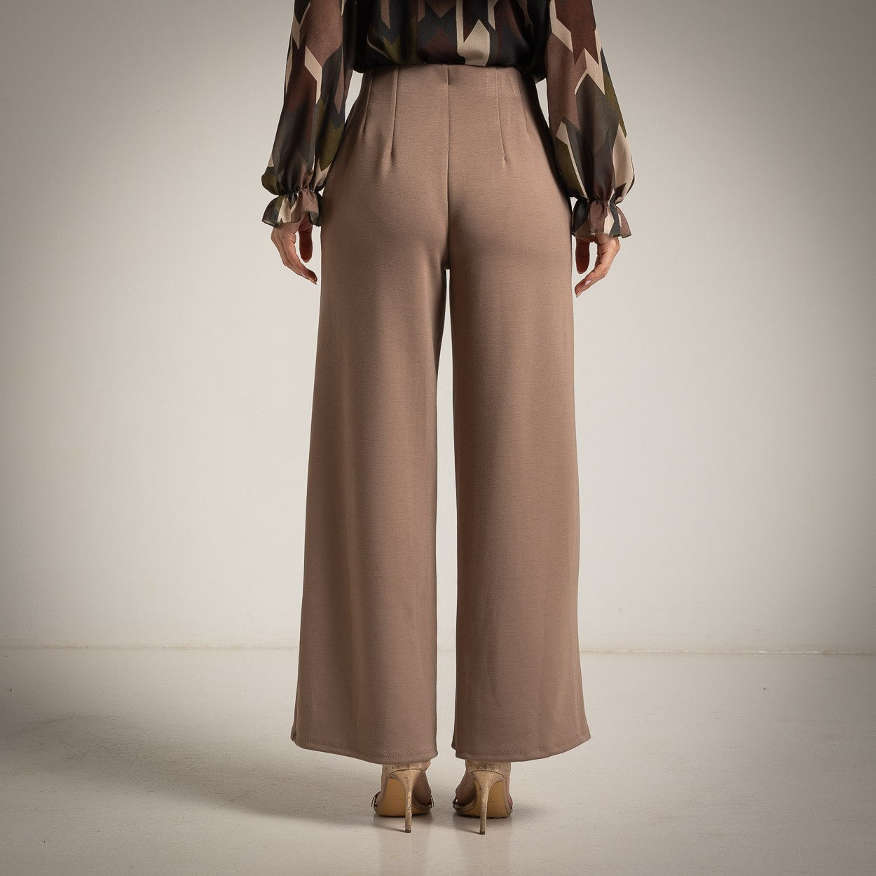 Almond Taupe high-waisted flared trousers with a pressed centre seam - back view