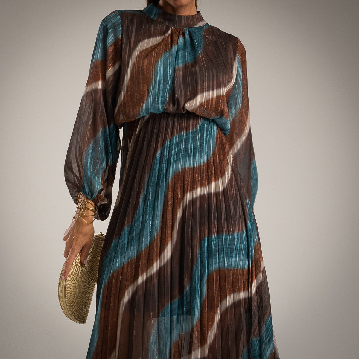 Close-up of abstract wave print pleated dress in chocolate and teal by MARIΓIOÚ
