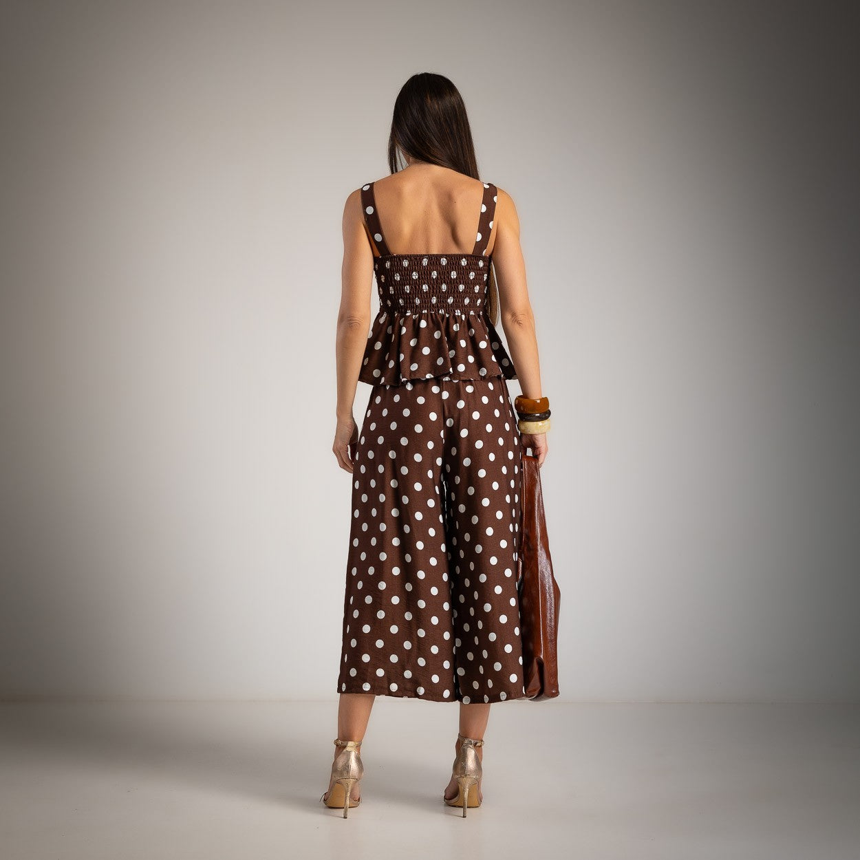 Back view of chocolate brown polka dot peplum top and wide leg pants set