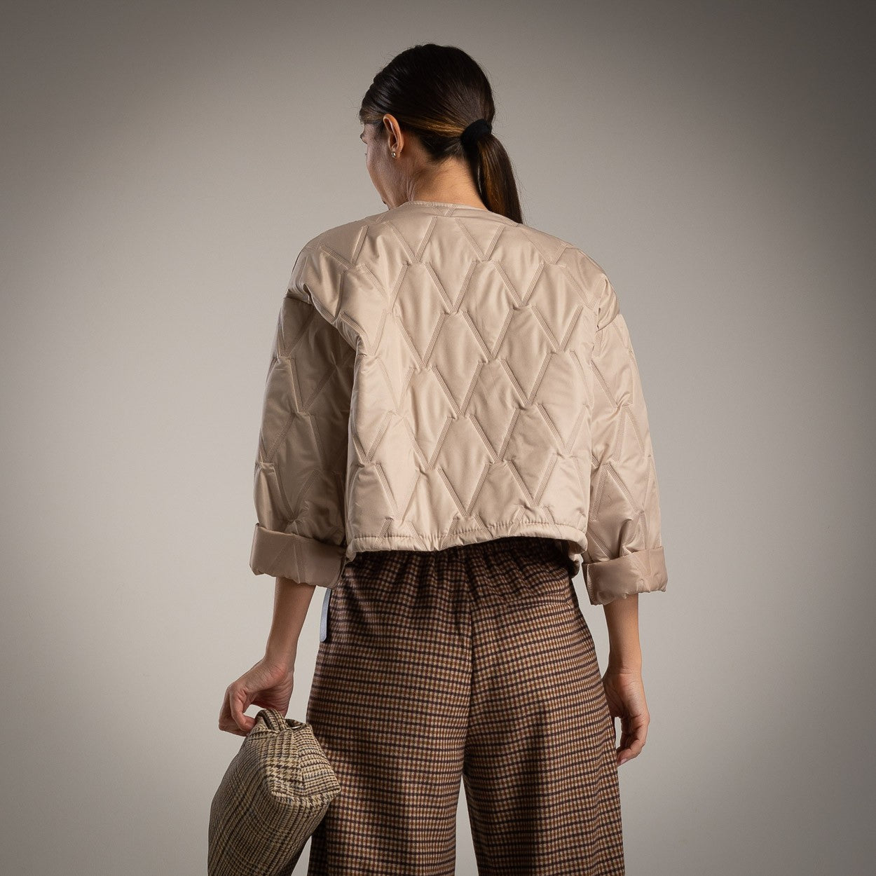 Beige quilted jacket with clover brooch back view