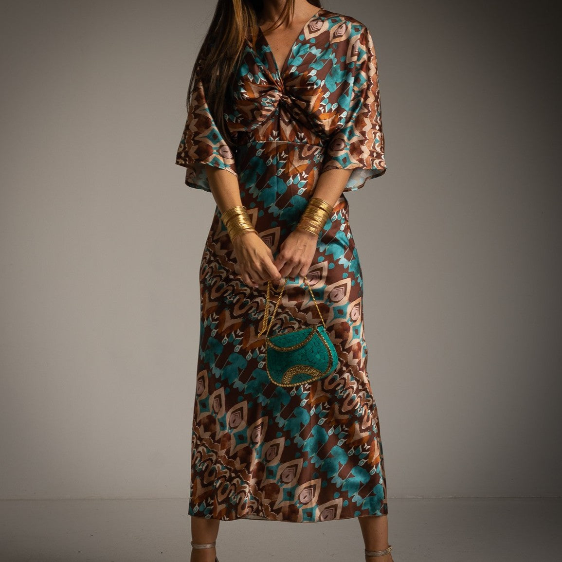 MARIΓIOÚ brown and turquoise abstract print resort maxi dress with twist front detail and gold accessories close up