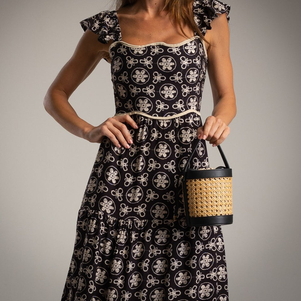 Close-up detail of MARIΓIOÚ retro black midi dress with cream floral design and square neckline