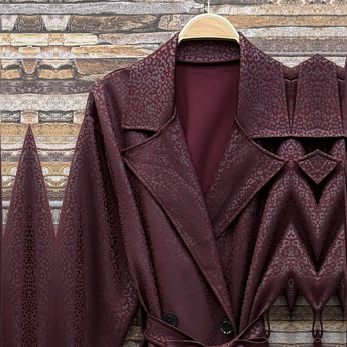 Deep Wine Red embossed leopard trench coat with wide lapels and tie belt - detail view