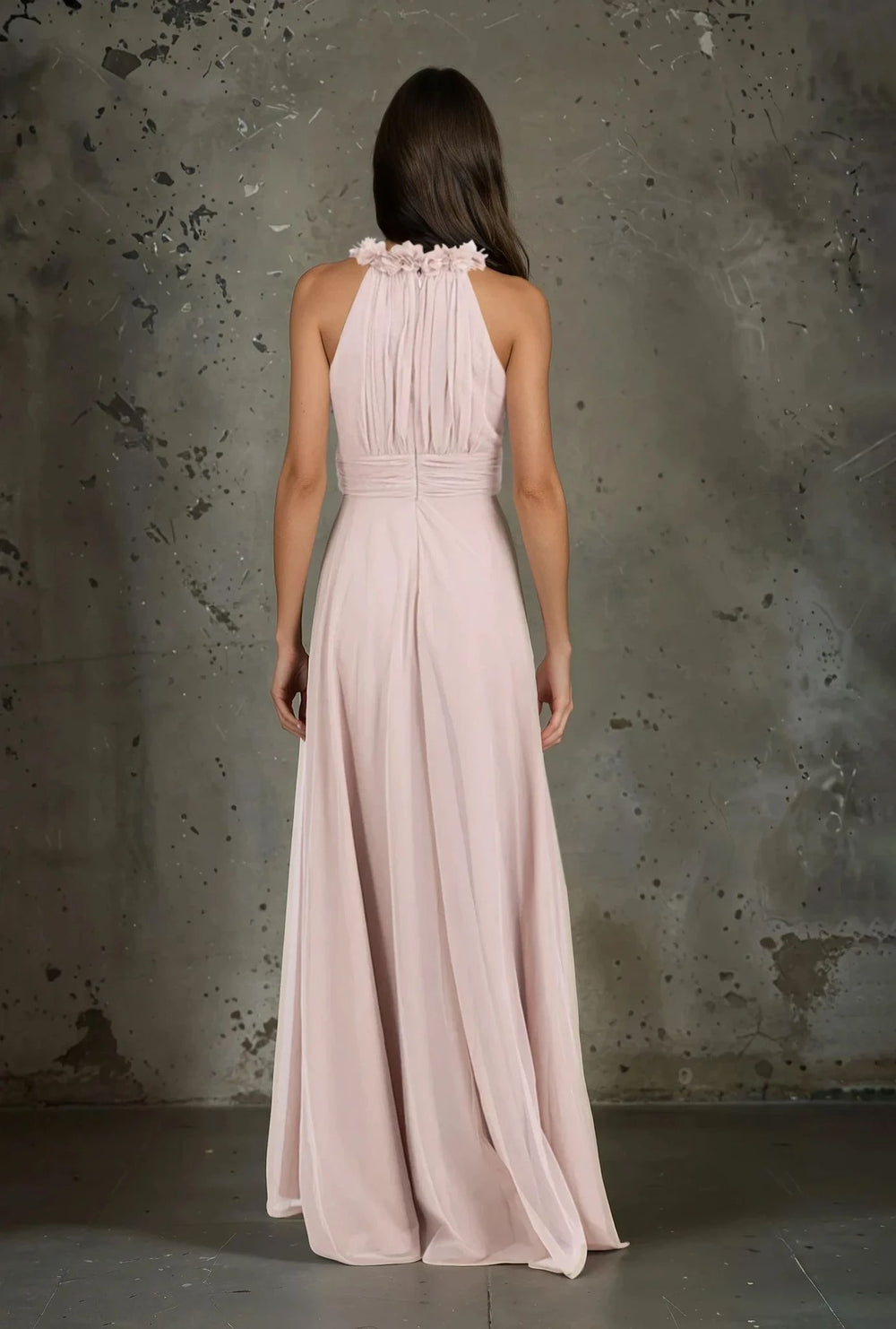 Back view of long blush pink evening dress with ruched halterneck and floral embellishments – perfect for formal occasions by MARIGIOÚ