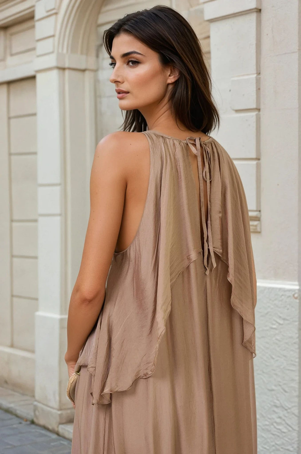 Stylish taupe one-size summer dress with ruffles, back view of a woman in front of a classic building, showcasing open-back design.