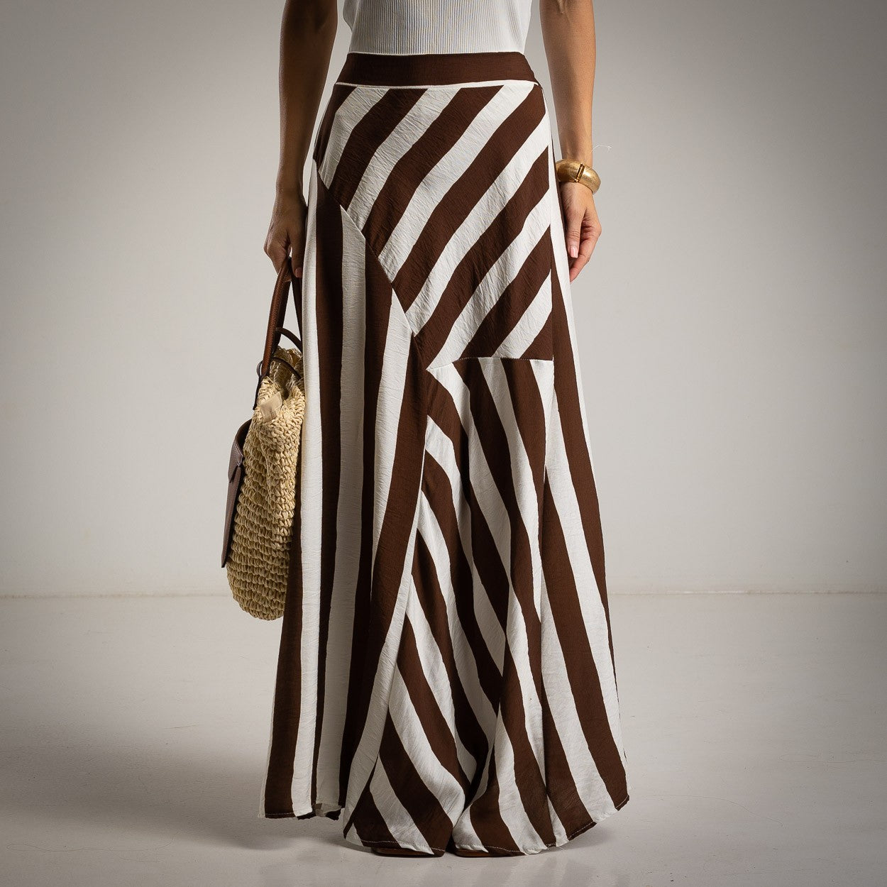 Front view of brown and white striped maxi skirt with asymmetrical panels and high waist