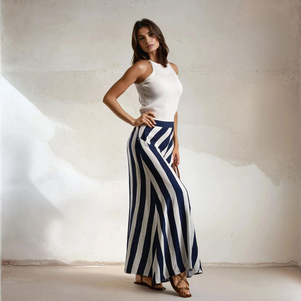 Model in navy striped maxi skirt styled with sleeveless white top and sandals