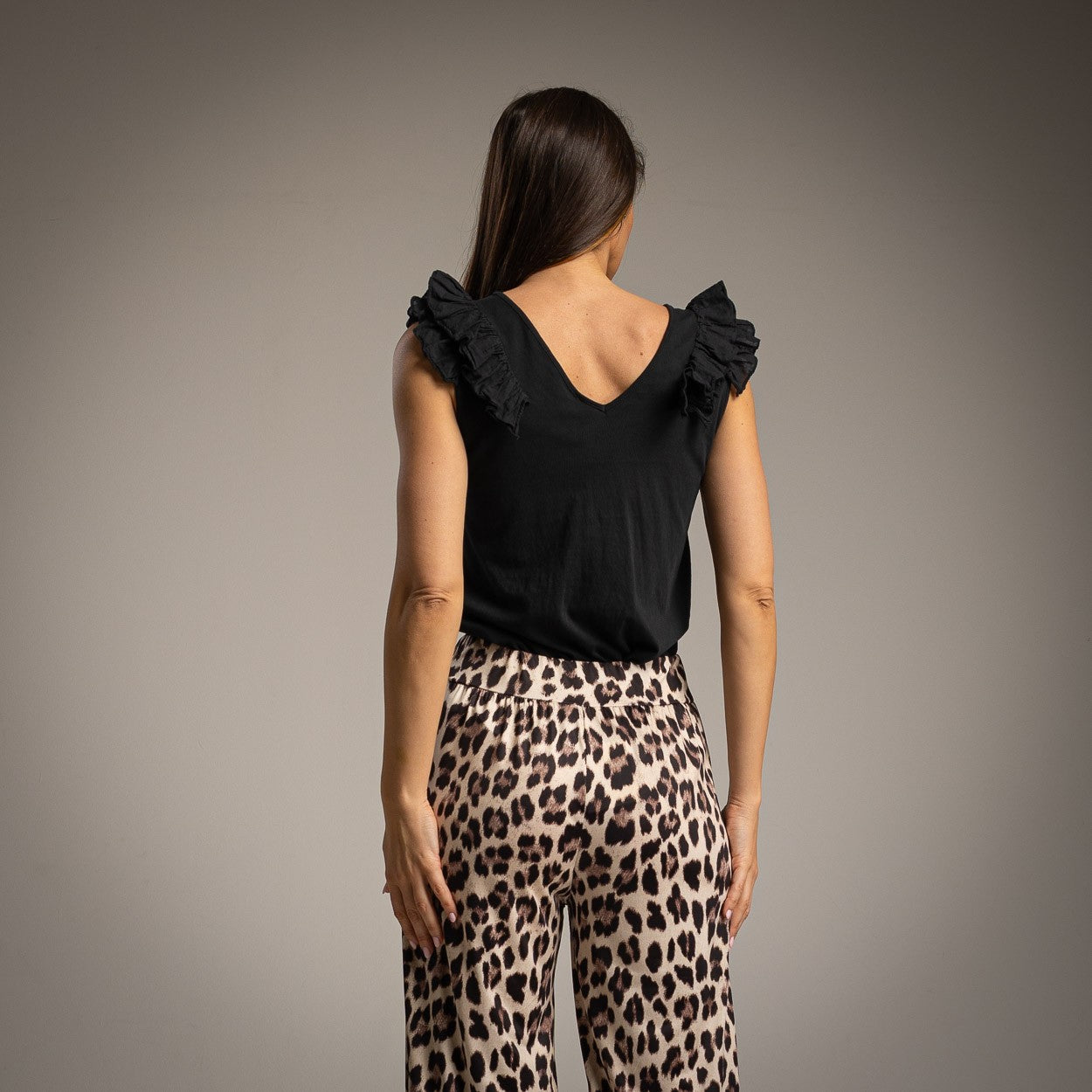 Black sleeveless top with ruffle straps and V-back detail