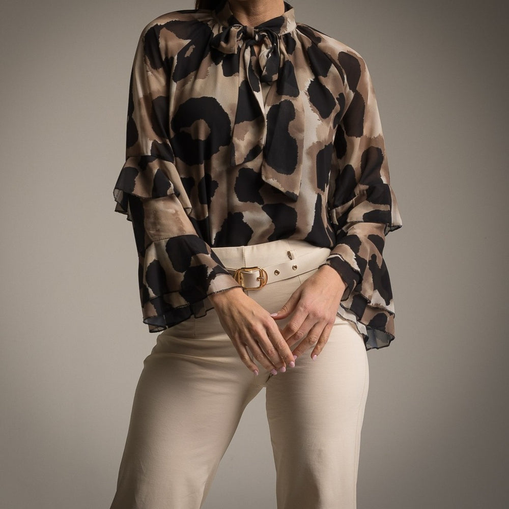 Close-up of black watercolour blouse with bow neckline and ruffle sleeves