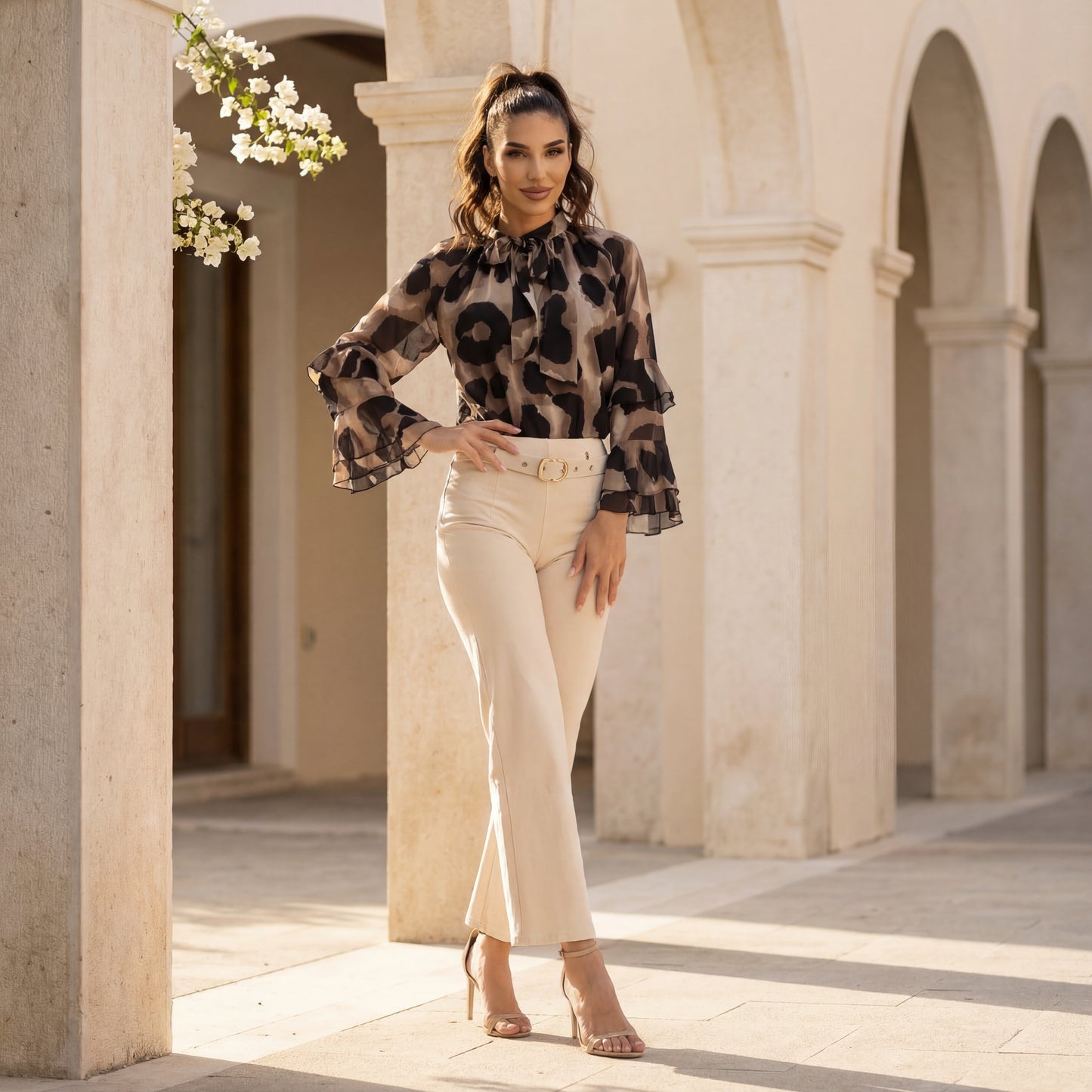 Black watercolour print blouse with ruffle sleeves and bow neckline styled with beige trousers