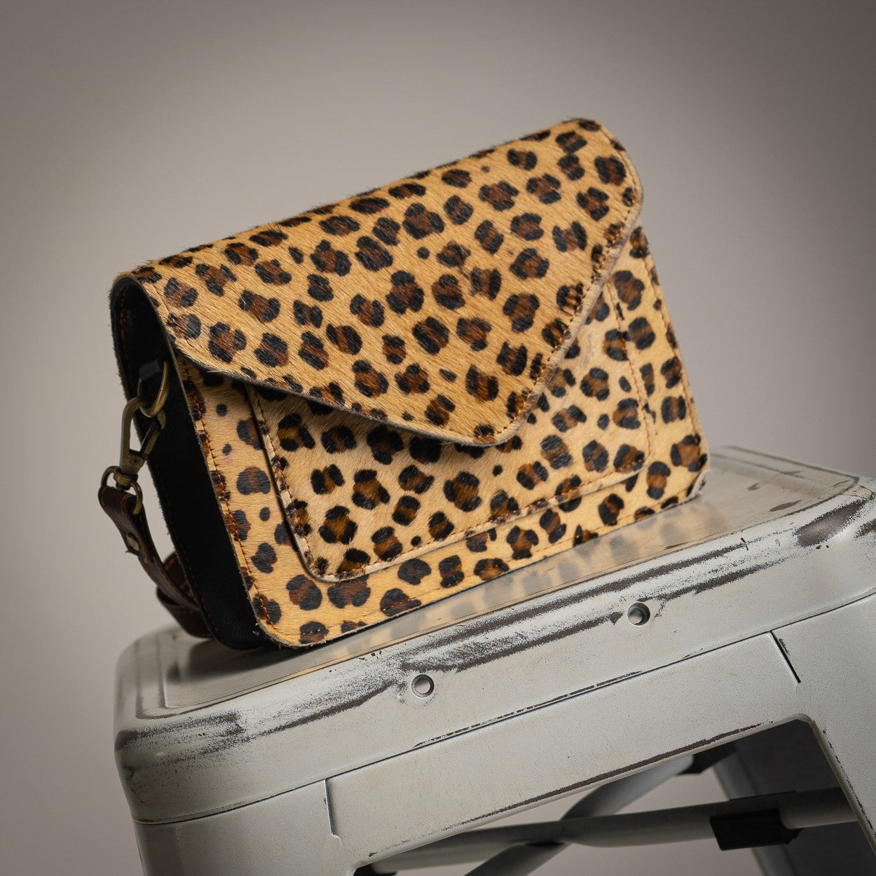 Cheetah pattern leather crossbody bag with flap closure
