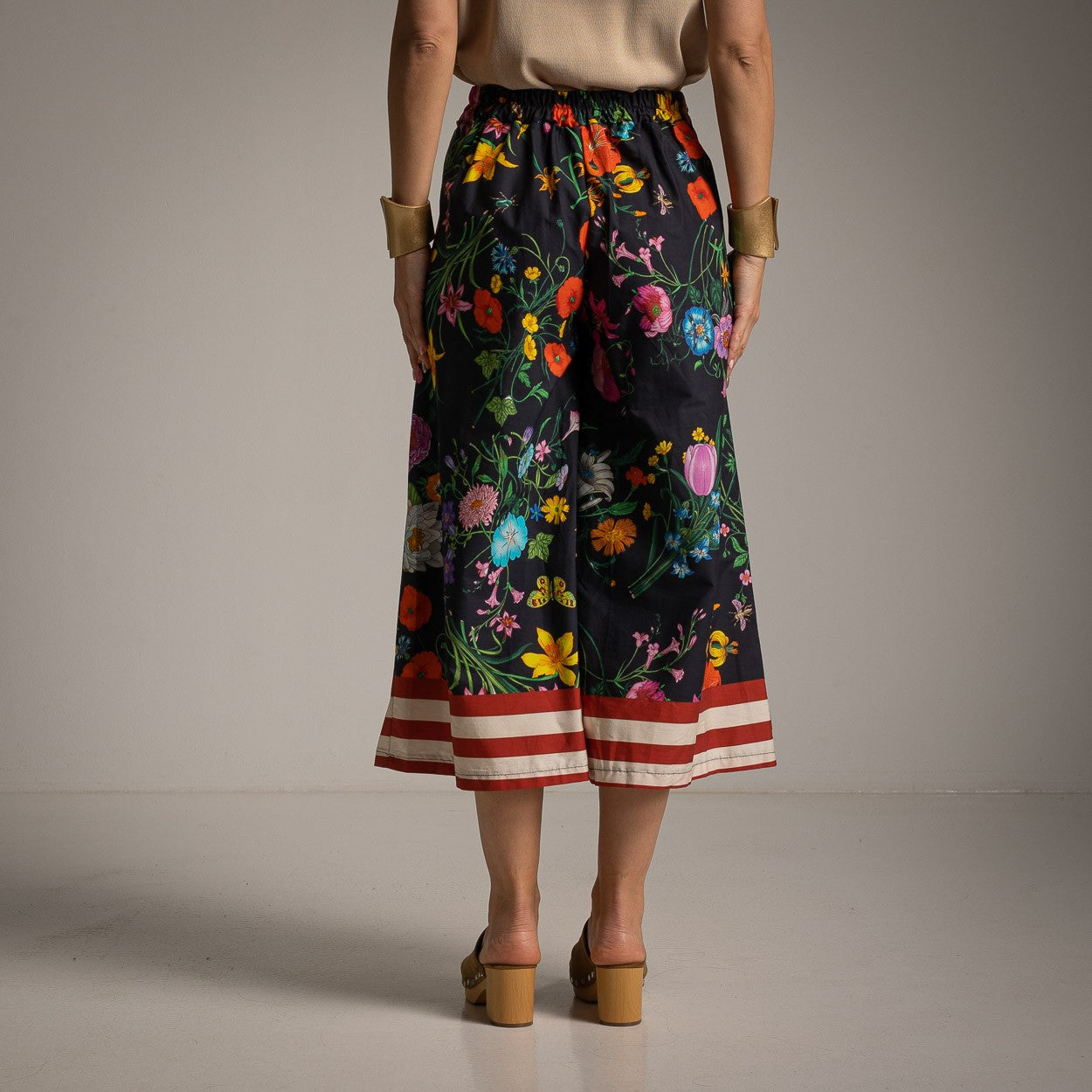 Back view of floral cotton culotte pants in Classic Black with an elastic waistband and colorful floral pattern.