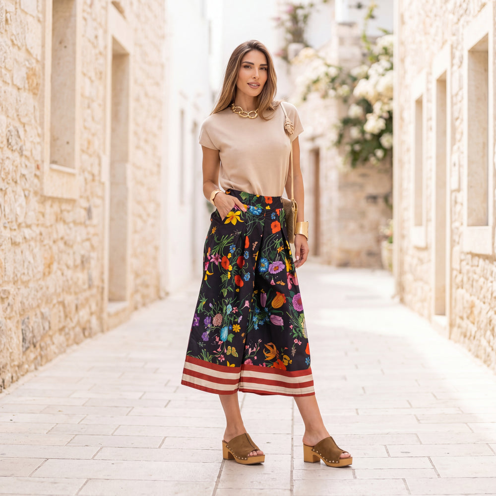 Woman wearing floral cotton culotte pants in Classic Black with a wide-leg silhouette and colorful botanical print.