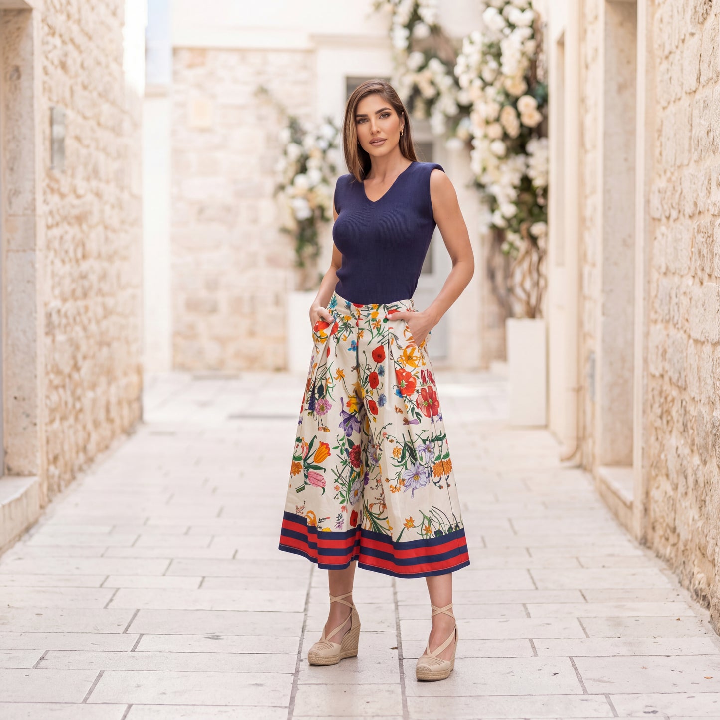 Woman wearing floral cotton culotte pants in Ivory White with a colorful botanical print and elegant wide-leg silhouette.