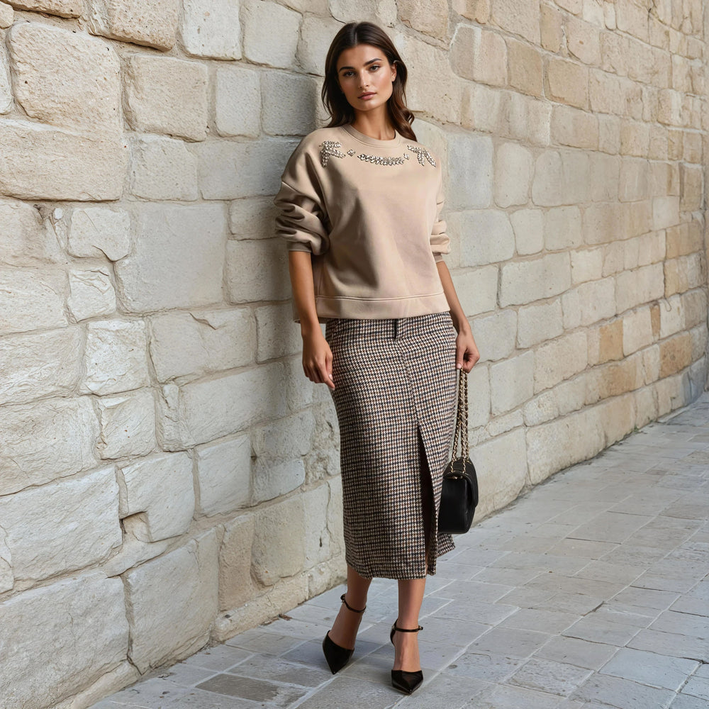 Embellished beige sweatshirt with large rhinestones styled with midi skirt – front view