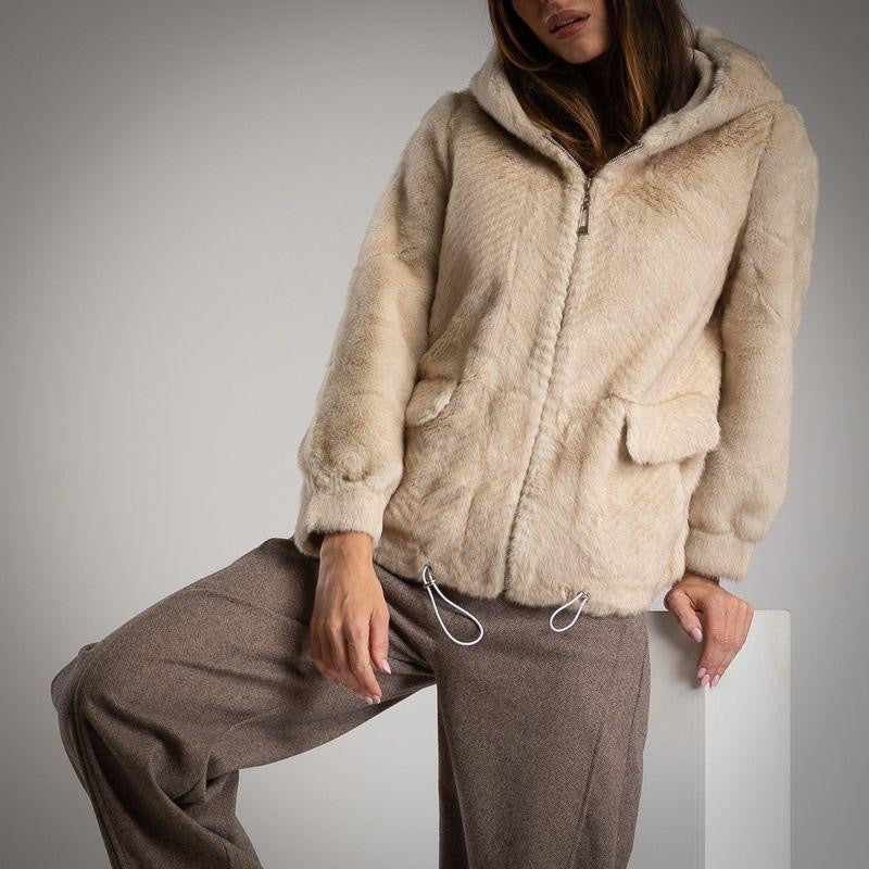 Close-up of MARIΓIOÚ faux fur hooded jacket in beige showing front zipper and pocket details.