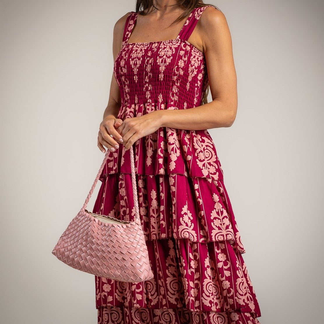 Close up of floral tiered midi dress with smocked bodice and layered ruffles in bougainvillea pink